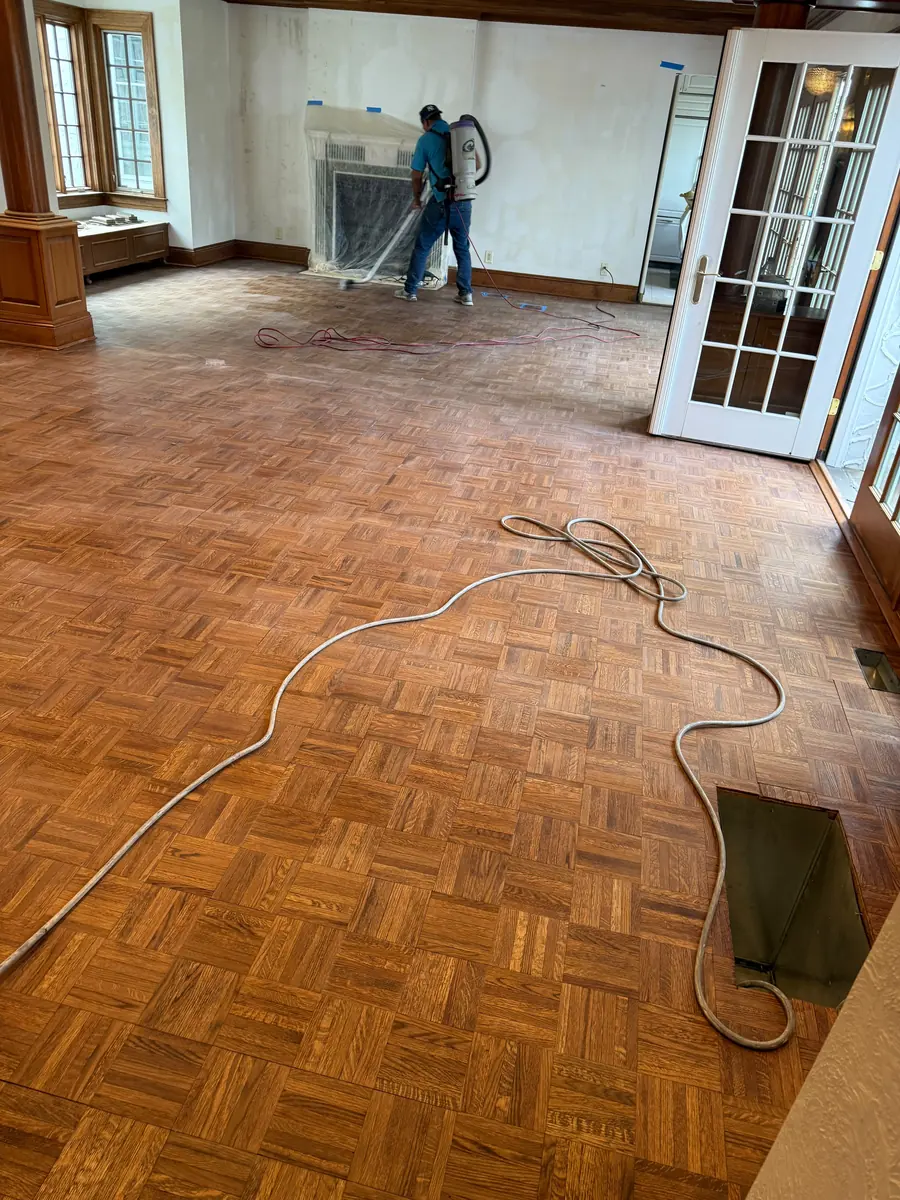 Crew member sanding a parquet floor